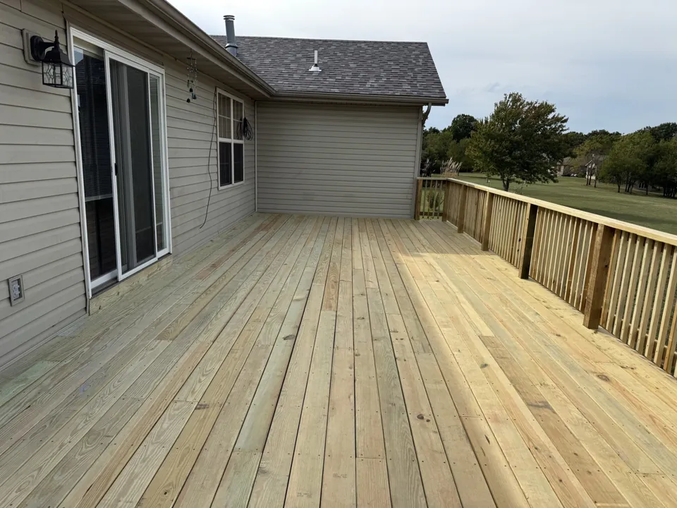 New wood deck boards and railing along the house.