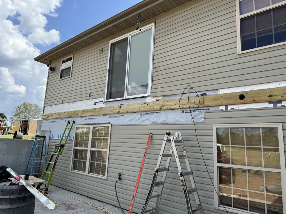 Exterior preparation around windows and the former deck connection.