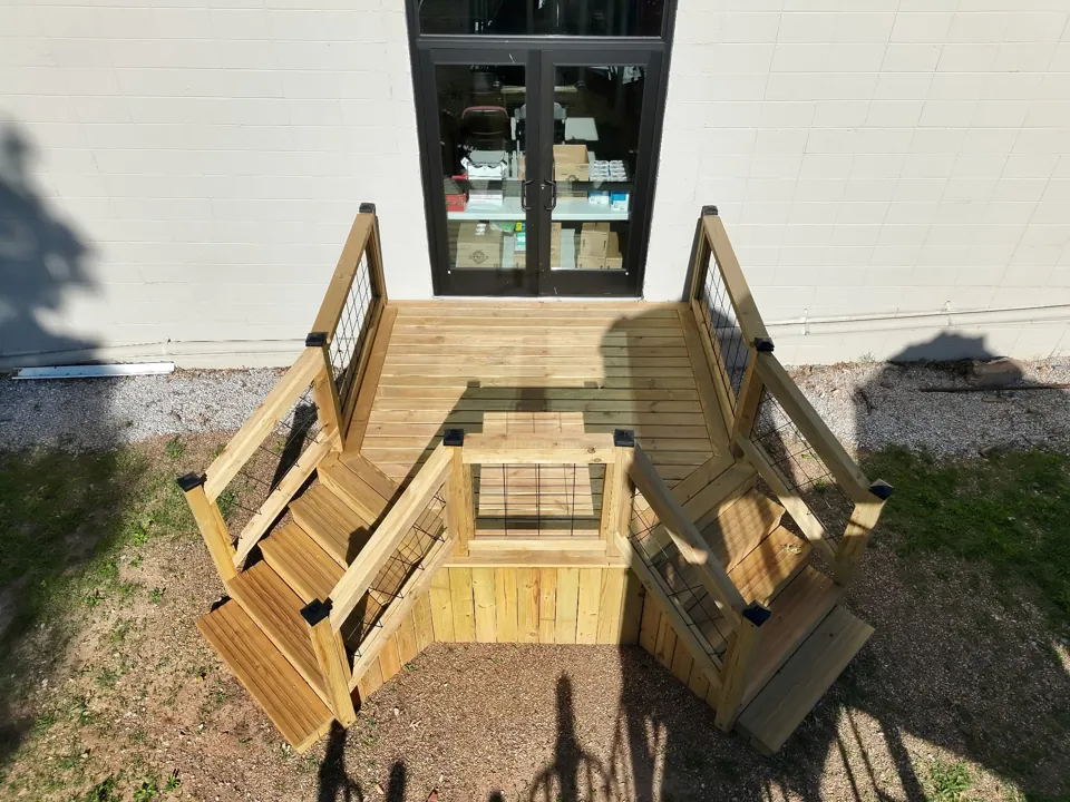 Deck boards, stair treads, and handrails in place at the church entry.